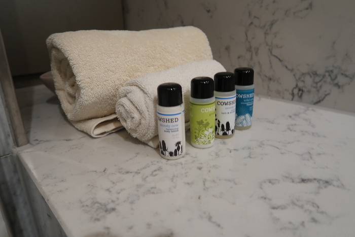 a group of small bottles next to a rolled towel