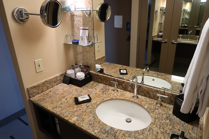 a bathroom sink with a mirror and a shelf