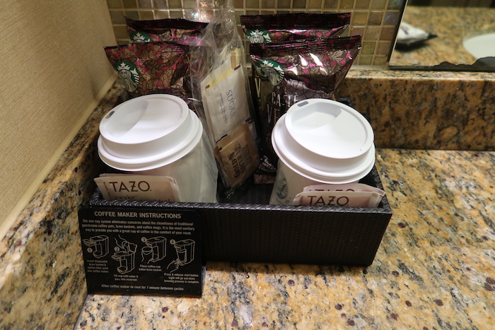 a coffee cups and coffee packets in a basket