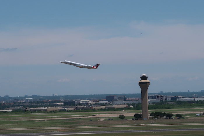 an airplane flying over a runway