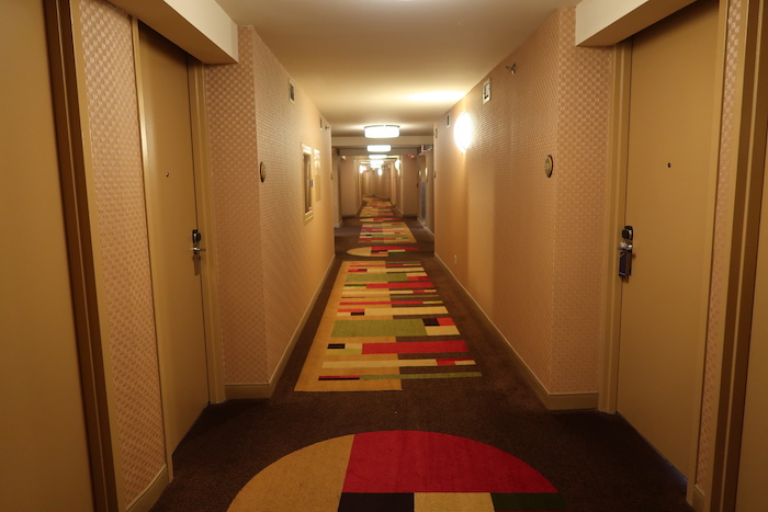 a hallway with colorful carpet and doors