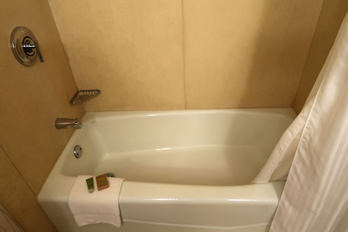 a bathtub with a towel and a bar on the side