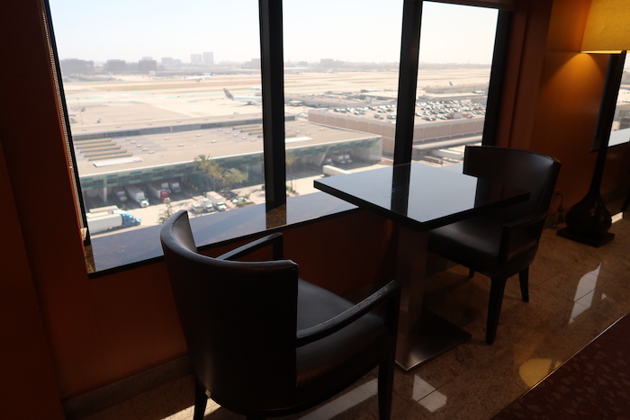 a table and chairs in a room with a view of an airport