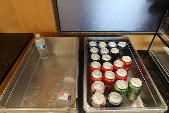 a tray of soda cans and water in a tray