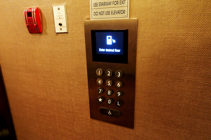 a elevator panel with a screen and a sign