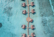 a group of huts on a body of water