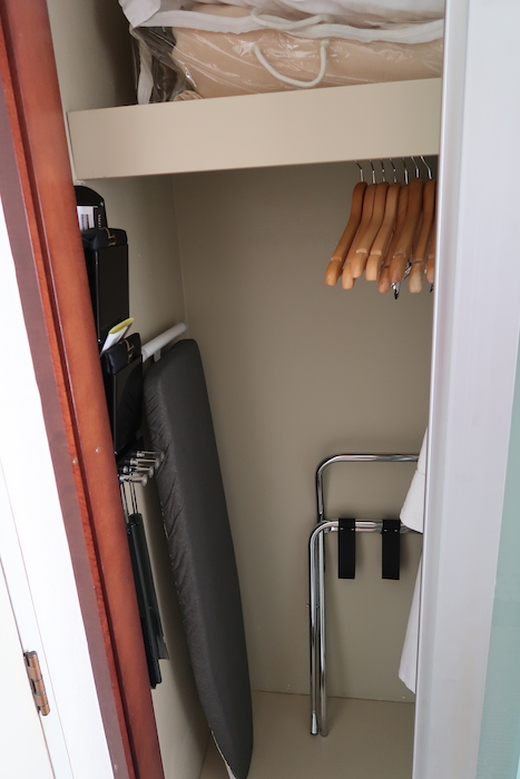 a closet with swingers and a towel rack