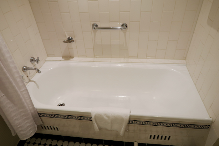 a bathtub with a towel on the wall