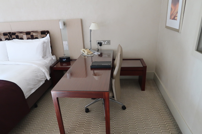 a desk with a telephone and a lamp in a hotel room