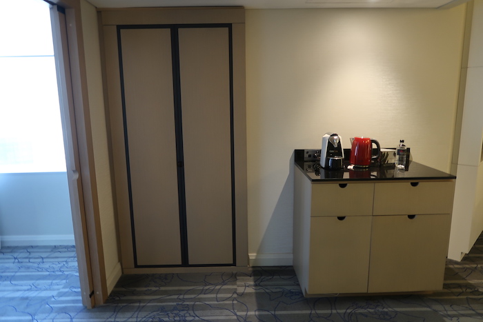 a kitchen with a cabinet and a coffee maker