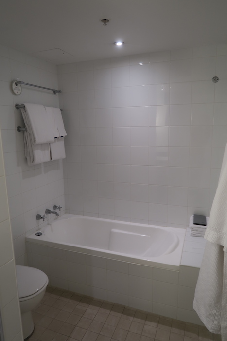 a white bathroom with a bathtub and toilet