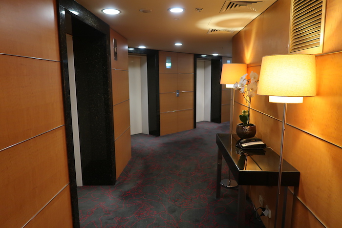 a hallway with a table and lamps