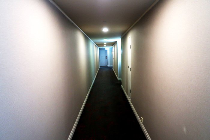 a long hallway with white walls and a door