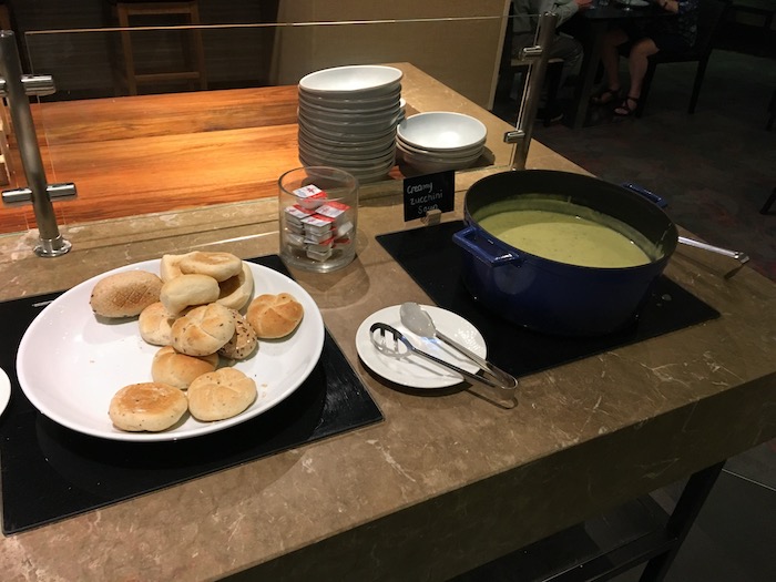food on a counter with plates of food and a pot of soup