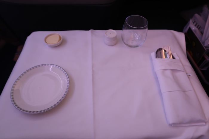 a table with a plate fork and knife and a glass