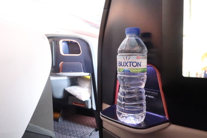 a bottle of water on a shelf in an airplane