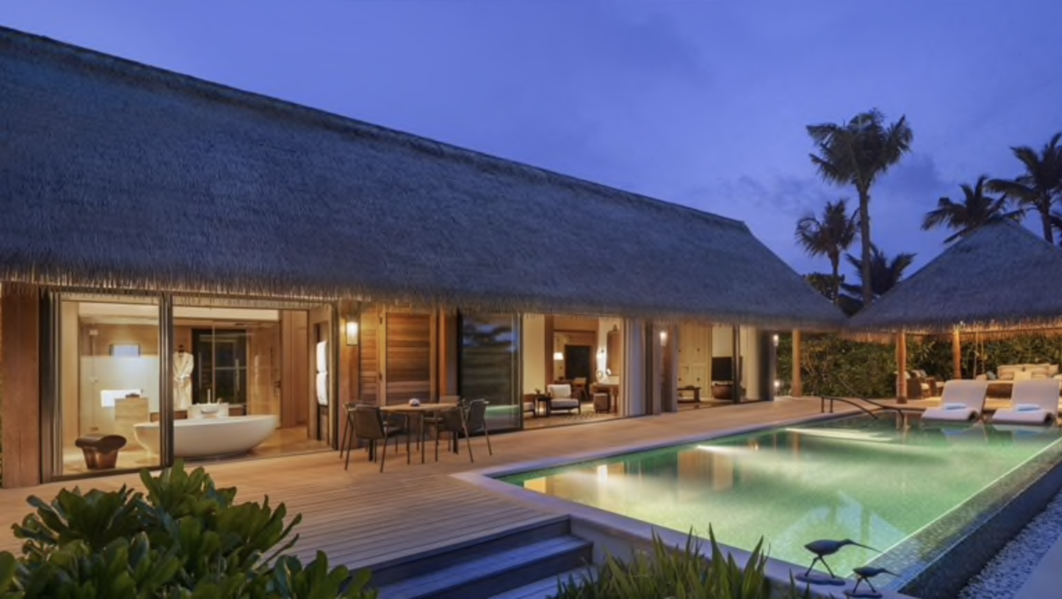a house with a pool and a thatched roof