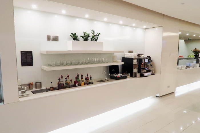 a white bar with shelves and bottles