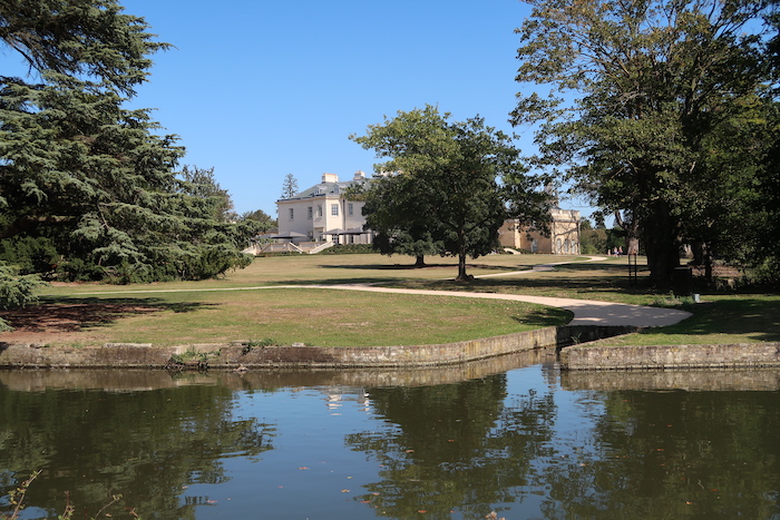 a body of water with trees and a building in the background