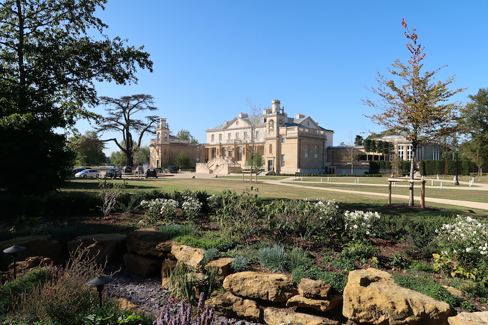 a large building with a lawn and trees