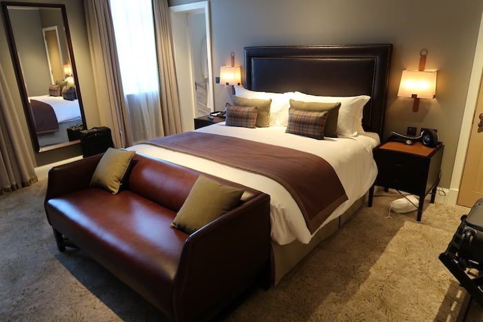 a bed with pillows and a leather couch in a hotel room