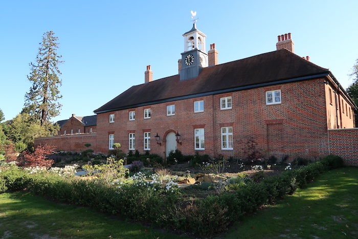 a brick building with a clock tower with Jane Austen's House Museum in the background