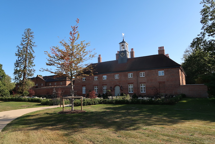 a brick building with a clock tower with Governor's Palace in the background