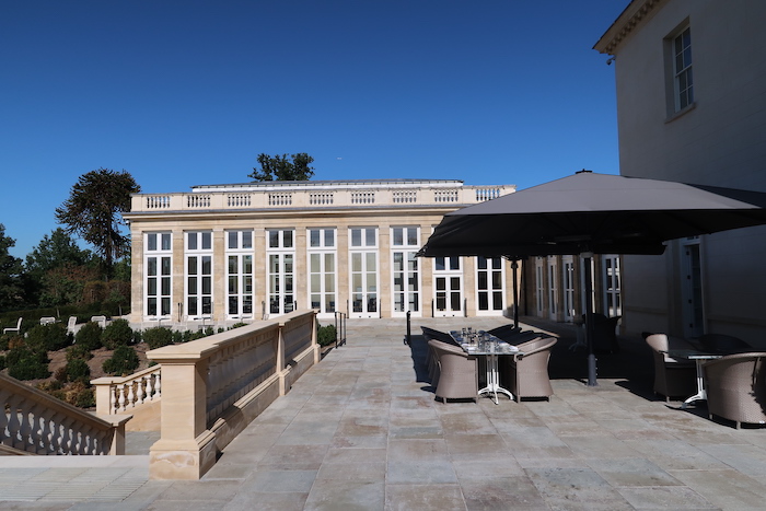 a patio with a table and umbrella in front of a building