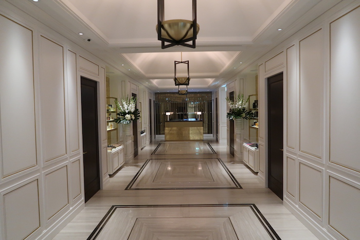 a hallway with white walls and black doors