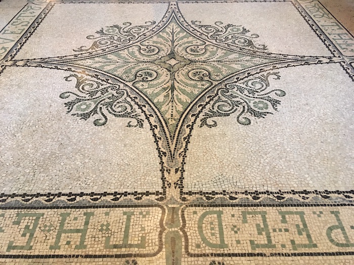 a mosaic floor with a design