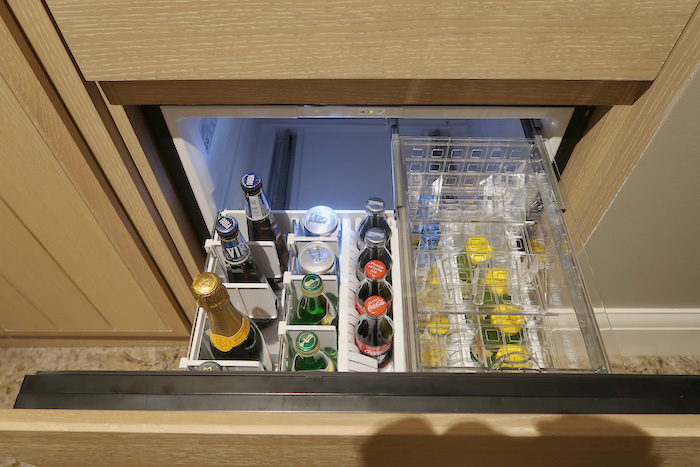 a mini fridge with bottles of beer and drinks inside