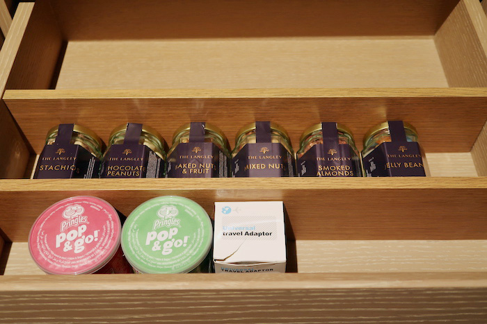 a shelf with jars of nuts and a box of travel adaptor