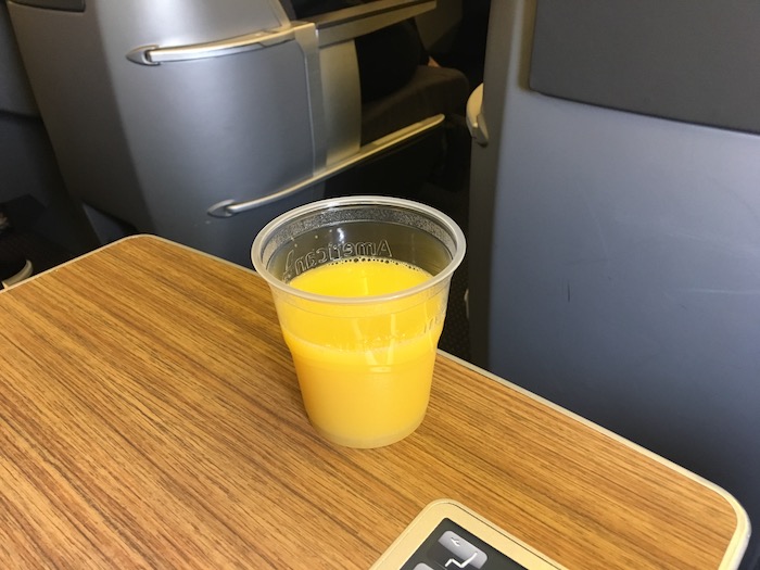 a plastic cup of orange juice on a table