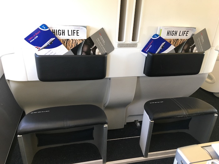 a seat with magazines and a magazine holder on the wall