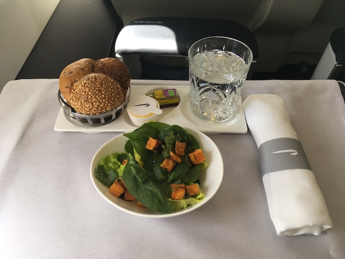 a plate of food and a glass of water on a tray