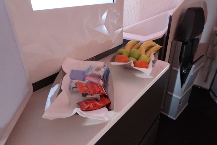 a bowl of fruit and a bag of candy on a counter
