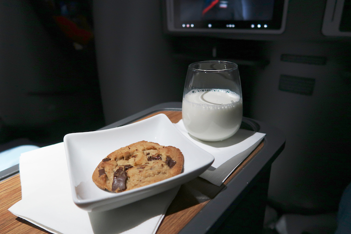 a glass of milk and a cookie on a tray