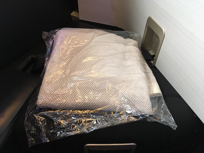 a white folded blanket in a plastic bag
