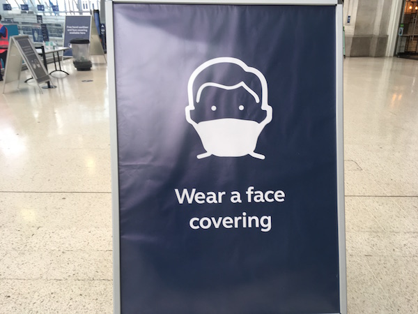 a sign with a face mask on it