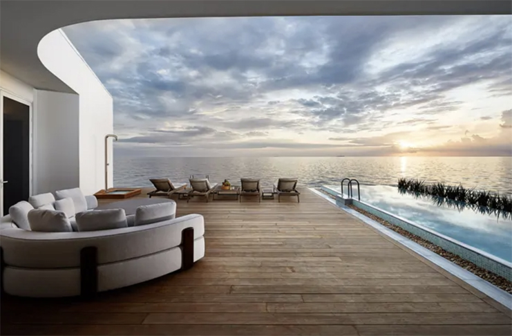 a deck with a pool and a couch overlooking the ocean