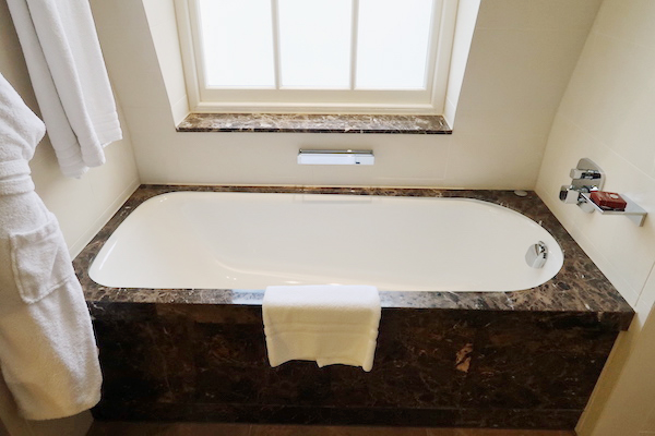 a bathtub with a white towel on the side