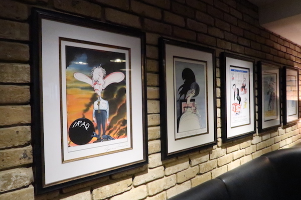 a group of framed pictures on a brick wall
