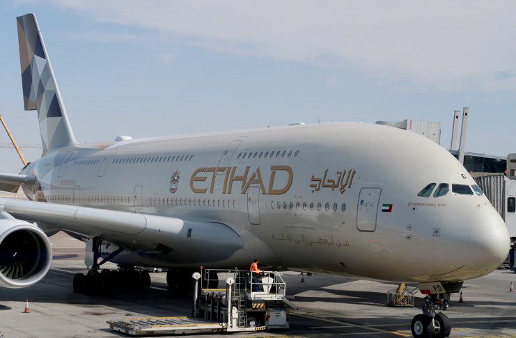 a large white airplane with gold lettering on it