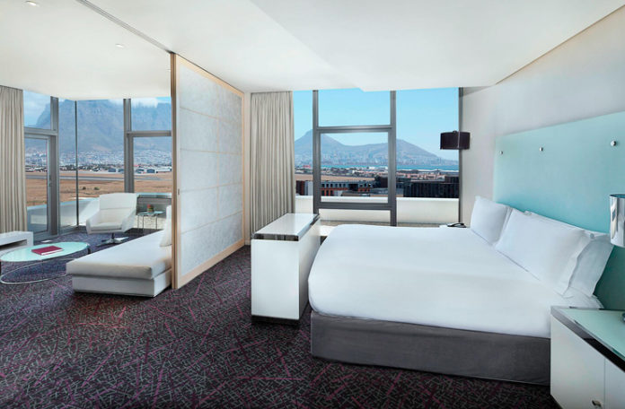 a room with a bed and a view of the city