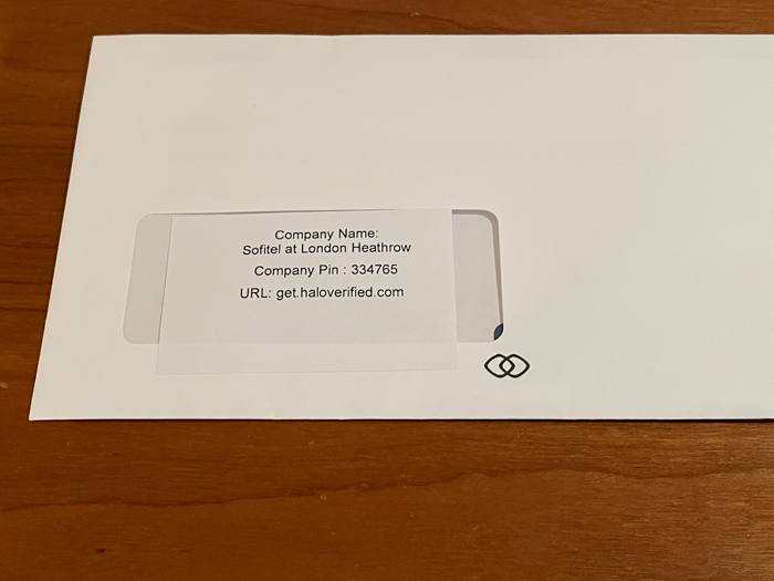 a white envelope with a piece of paper on a wood surface