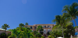 a pool with palm trees and a building in the background