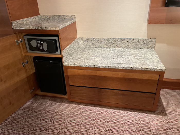 a counter top with a microwave and a black dishwasher