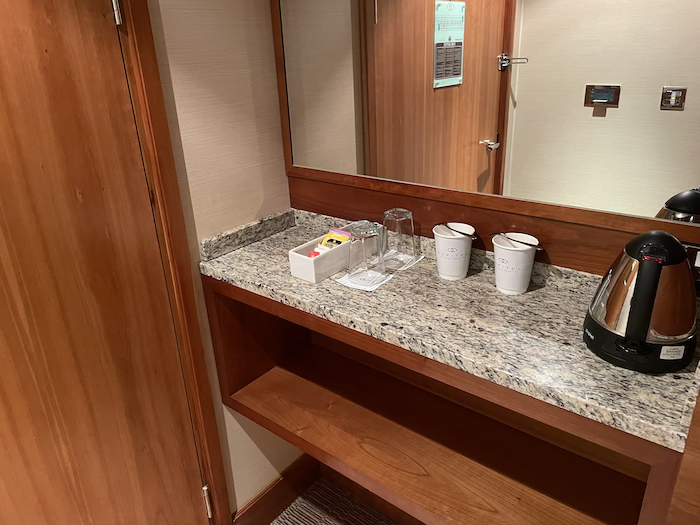 a counter with a mirror and a few cups on it