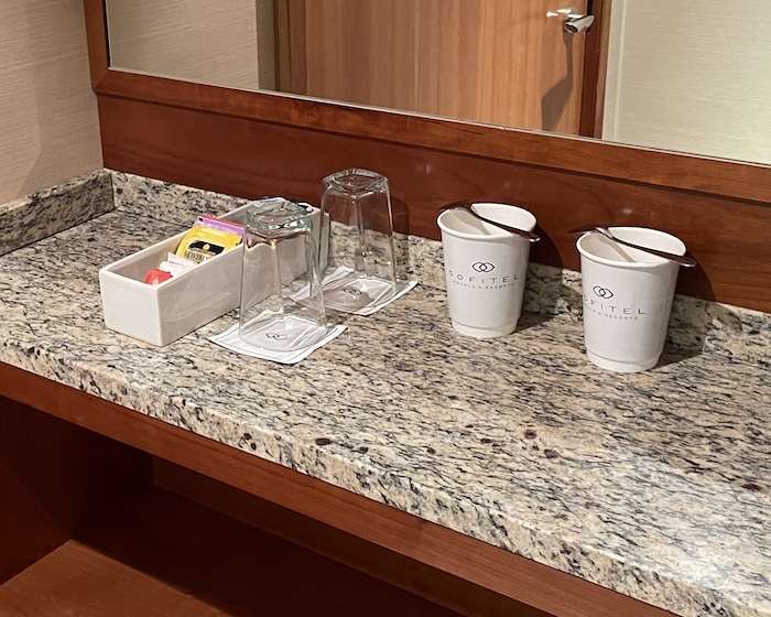 a counter top with a couple cups and utensils on it