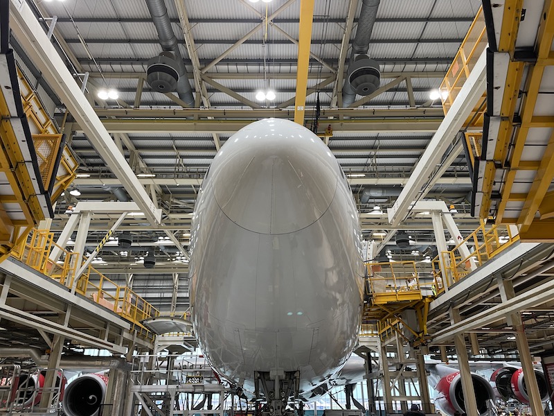 a large white airplane in a factory